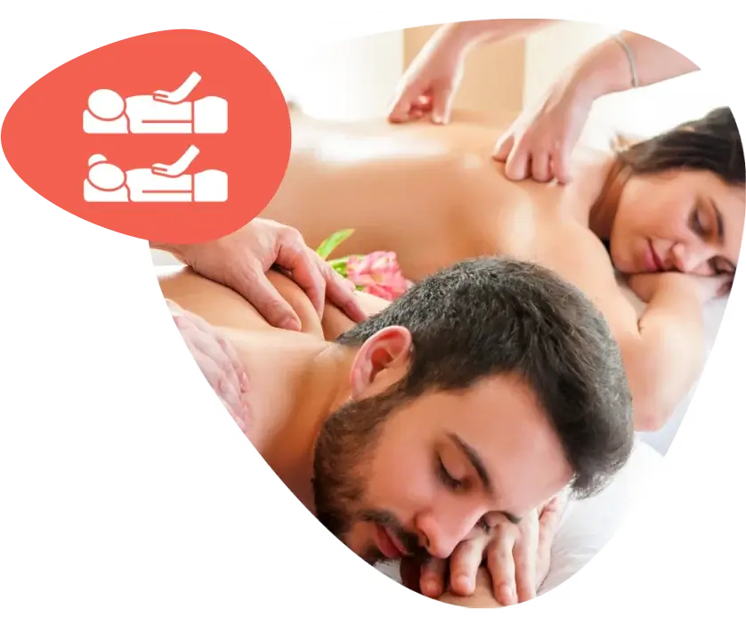 Two people receiving a relaxing couple’s massage side by side in a spa setting.