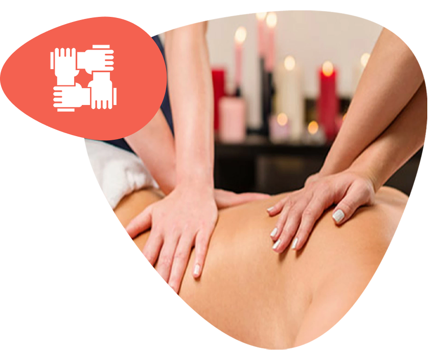 A person receiving a 4-hands massage, with two therapists working simultaneously on their back for deep relaxation.